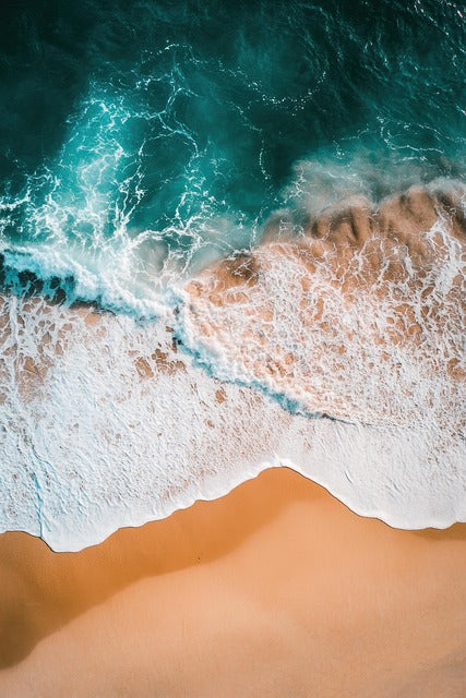 Ocean waves rolling onto the shore at sunset
